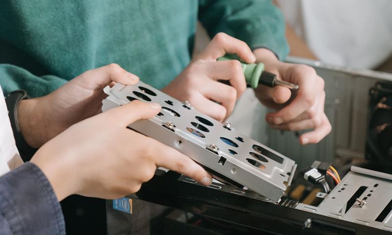 Techniciens manipulant un composant informatique lors d'une opération de maintenance